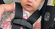 Alani joined the competition — help win amazing prizes! baby, infant, car_seat, child, straps, safety_harness, floral_dress, seat_padding, cute, wide_eyes, looking, indoors, young_child, person, small_hand, pink, black_straps, head_support, expression, secure