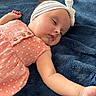 baby, sleeping, headband, bow, pink_dress, polka_dot, wooden_buttons, arm, blanket, soft_texture, infant, child, peaceful, cute, napping, indoors, portrait, closeup, skin, relax