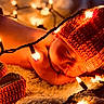 baby, newborn, sleeping, hat, knitted, orange, fairy_lights, lights, blanket, soft, booties, cozy, resting, infant, warm, cute, portrait, holiday, decor, peaceful