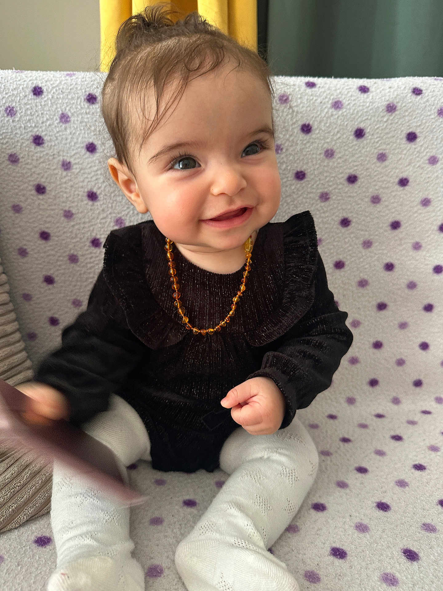 Mounia a rejoint le concours — aidez-le/la à gagner de superbes lots ! baby, smile, child, polka_dot, blanket, black_clothing, white_tights, happy, sitting, indoor, cute, face, person, necklace, hand, toy, cozy, pattern, infant, portrait