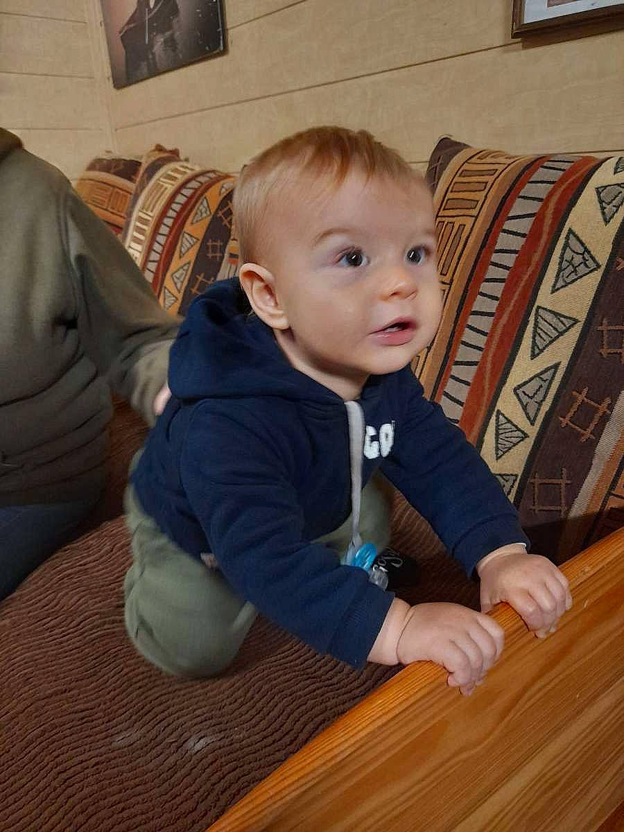 Raphaël a rejoint le concours — aidez-le/la à gagner de superbes lots ! baby, baby_toddler_clothing, cheek, child, comfort, couch, facial_expression, floor, flooring, fun, hardwood, iris, person, picture_frame, sitting, sleeve, table, toddler, varnish, wood