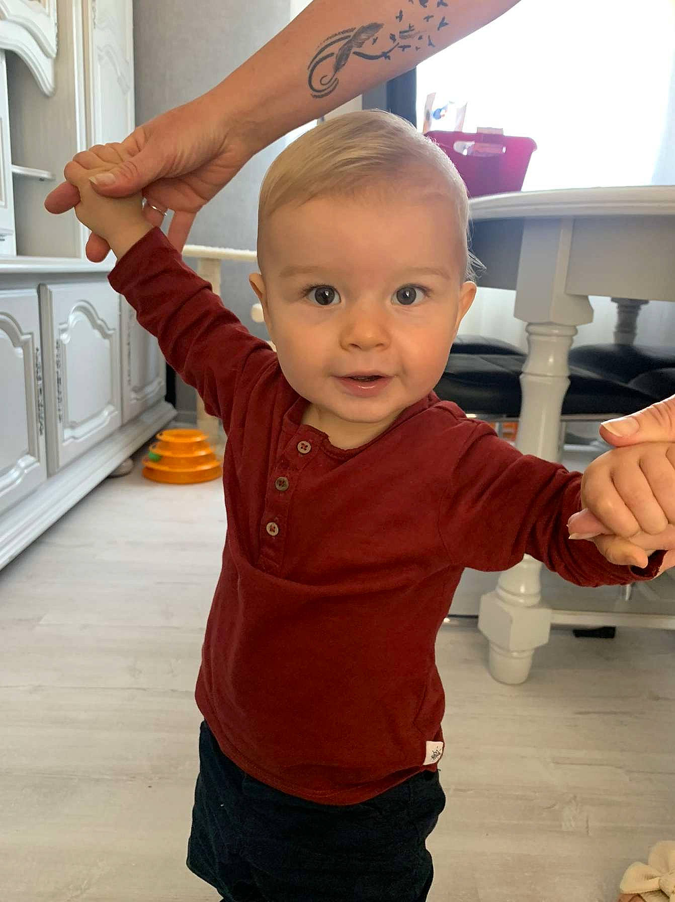 Raphaël participe au concours pour gagner de l'argent avec cette photo : arm, baby, baby_toddler_clothing, cheek, child, finger, floor, flooring, gesture, hand, happy, joint, nose, person, product, sleeve, standing, t_shirt, thumb, toddler
