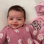 Ayna participe au concours pour gagner de l'argent avec cette photo : baby, infant, smiling, pink_onesie, daisy_pattern, blanket, plush_toy, soft_toy, lying_down, indoors, cute, child, face, happy, cozy, comfort, sleepy, toy, hand, head