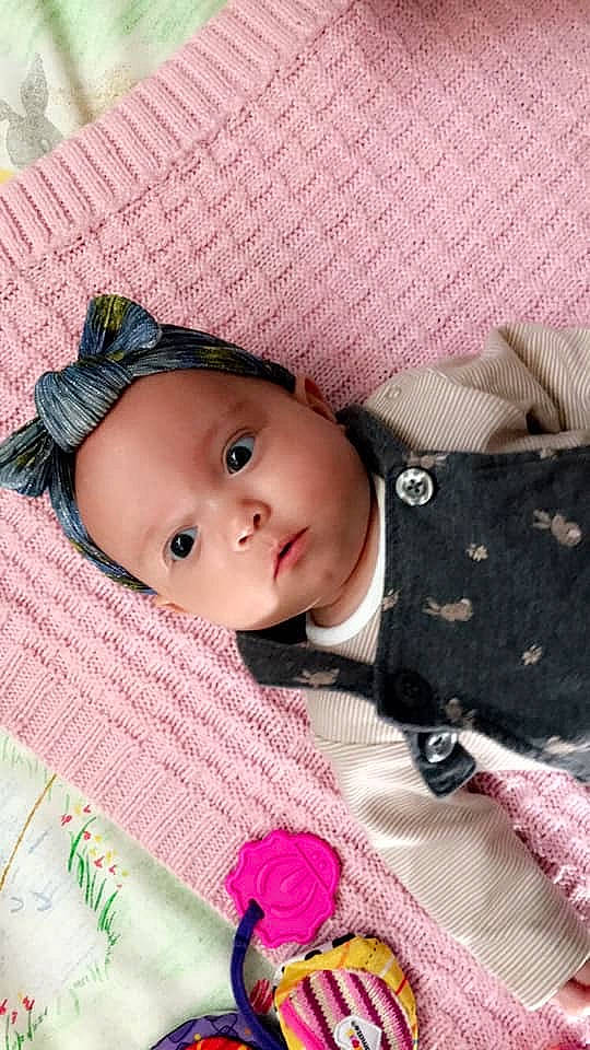 Dolly is registered to the contest to win money with this photo: baby, baby_products, beauty, bonnet, cheek, child, doll, eye, headgear, knitting, lip, outerwear, person, pink, plant, product, skin, smile, textile, toddler