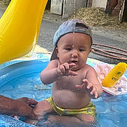 Miquel participe au concours pour gagner de l'argent avec cette photo : animal, baby, barn, cap, child, colorful, curious, droplets, fun, hand, hay, horse, inflatable_pool, outdoor, person, play, sitting, summer, water, yellow_shorts