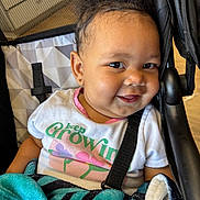 Leyah Swink is registered to the contest to win money with this photo: baby, child, smile, curly_hair, stroller, blanket, clothing, earring, face, infant, person, happy, portrait, seated, indoors, baby_toddler, cute, young_child, black_hair, skin