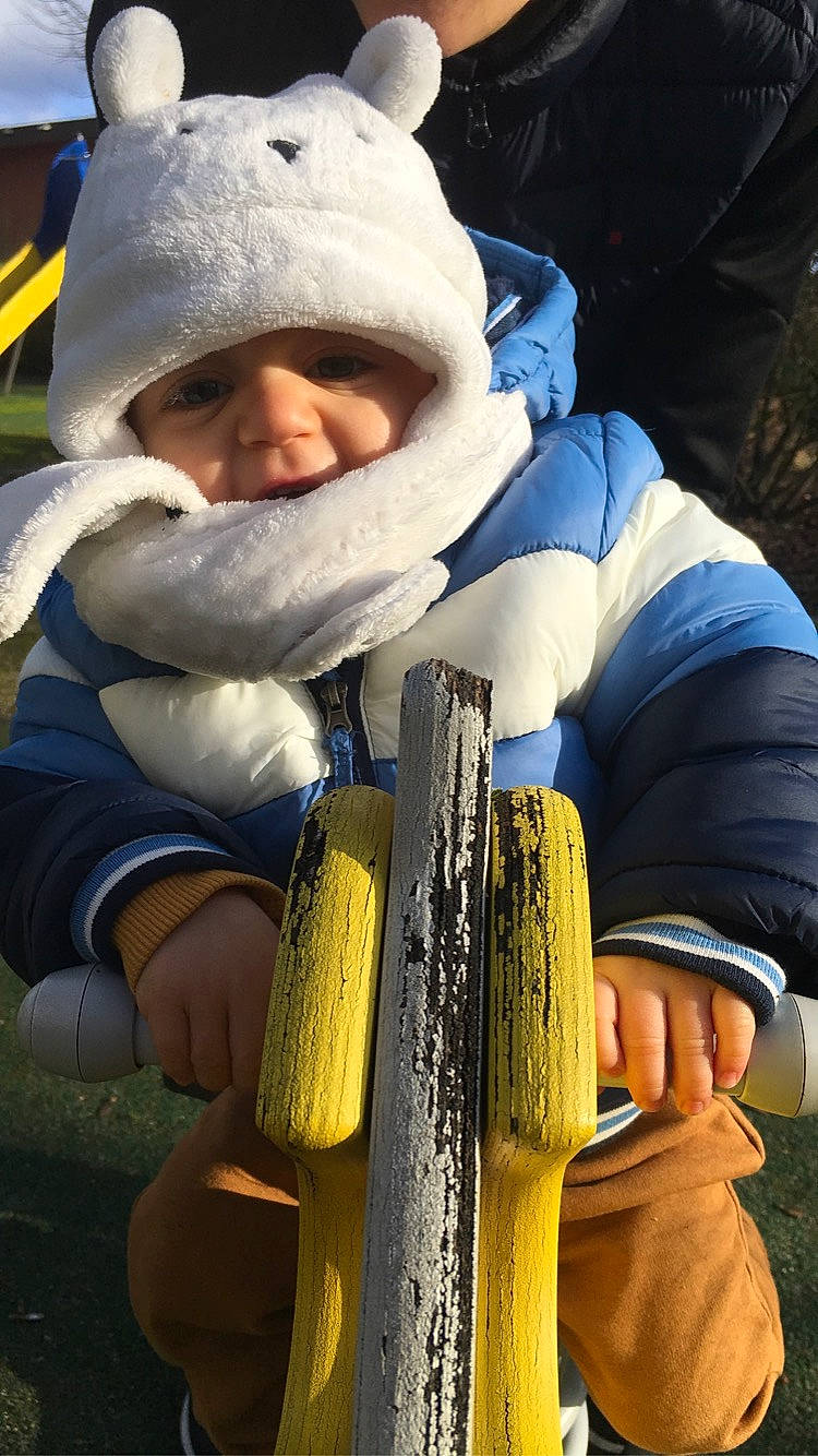 Julien participe au concours pour gagner de l'argent avec cette photo : beanie, child, electric_blue, fur, glove, grass, happy, headwear, natural_material, people_in_nature, person, personal_protective_equipment, recreation, safety_glove, smile, thumb, toddler, tree, winter, yellow