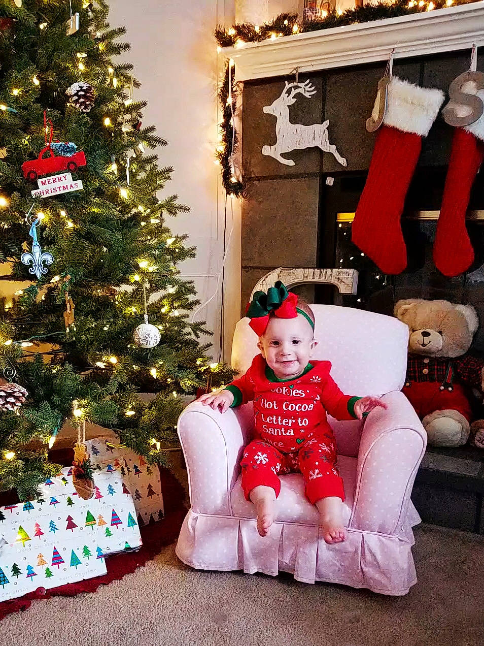 Everley is registered to the contest to win money with this photo: child, christmas, christmas_decoration, christmas_eve, christmas_lights, christmas_ornament, christmas_stocking, christmas_tree, event, holiday, holiday_ornament, home, interior_design, joy, person, plant, room, santa_claus, sitting, toddler