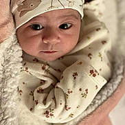 Janna participe au concours pour gagner de l'argent avec cette photo : baby, infant, face, eyes, hat, clothing, blanket, floral_pattern, soft_texture, wrapped, cute, newborn, cozy, warm, portrait, indoors, child, person, headwear, sleepwear