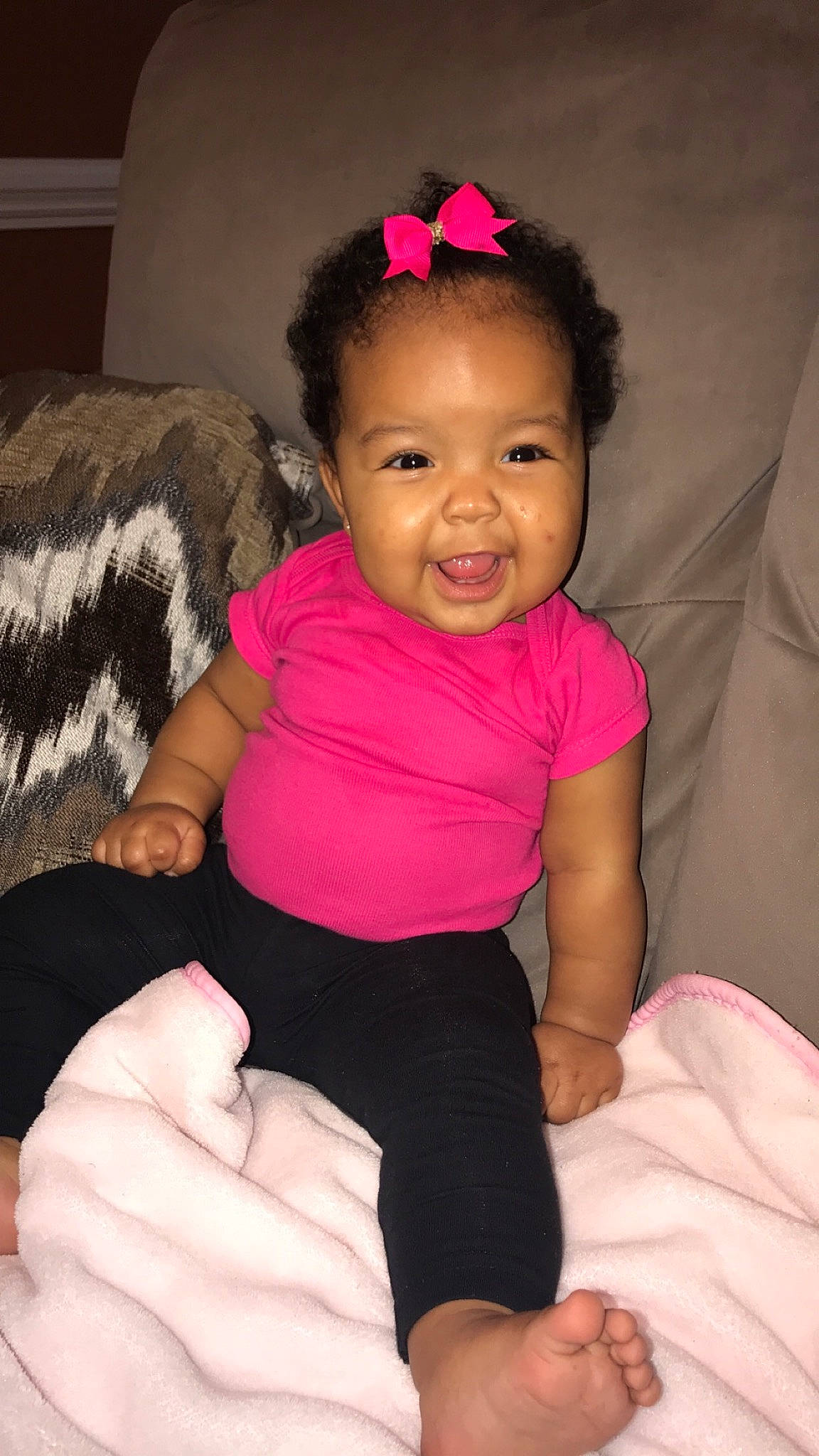 Loren is registered to the contest to win money with this photo: arm, baby, baby_toddler_clothing, cheek, child, finger, hair_accessory, joy, neck, person, pink, sitting, skin, smile, thumb, toddler