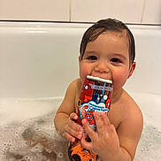 Ayaz is registered to the contest to win money with this photo: child, toddler, bath, bathtub, bubbles, foam, bath_toy, toy, wet_hair, smiling, cute, portrait, hands, water, play, bath_time, skin, tile, bathroom, happy