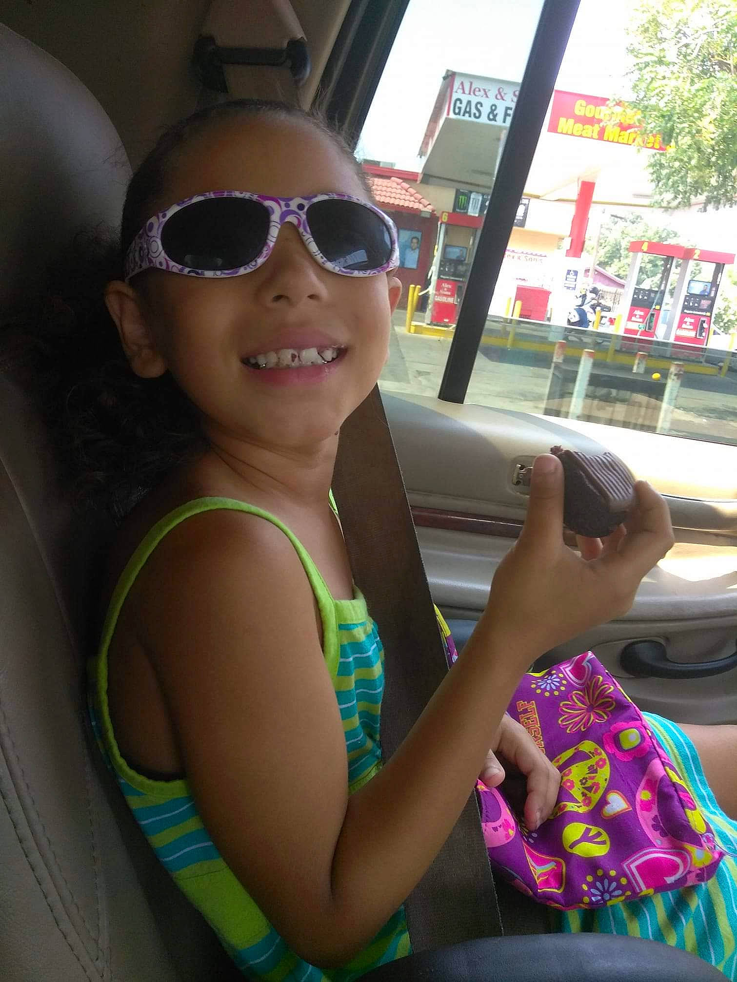 Jewel is registered to the contest to win money with this photo: abdomen, black_hair, child, cool, day, eyewear, fashion_accessory, fun, girl, glasses, hairstyle, happiness, joy, person, product, smile, summer, sunglasses, toddler, trunk