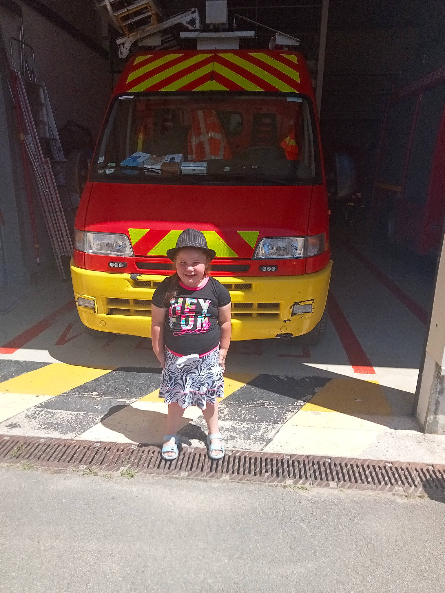 Tal a rejoint le concours — aidez-le/la à gagner de superbes lots ! ambulance, asphalt, automotive_design, automotive_exterior, automotive_lighting, automotive_tire, bumper, car, commercial_vehicle, emergency_service, firefighter, headwear, joy, land_vehicle, motor_vehicle, person, road_surface, service, shorts, tints_and_shades