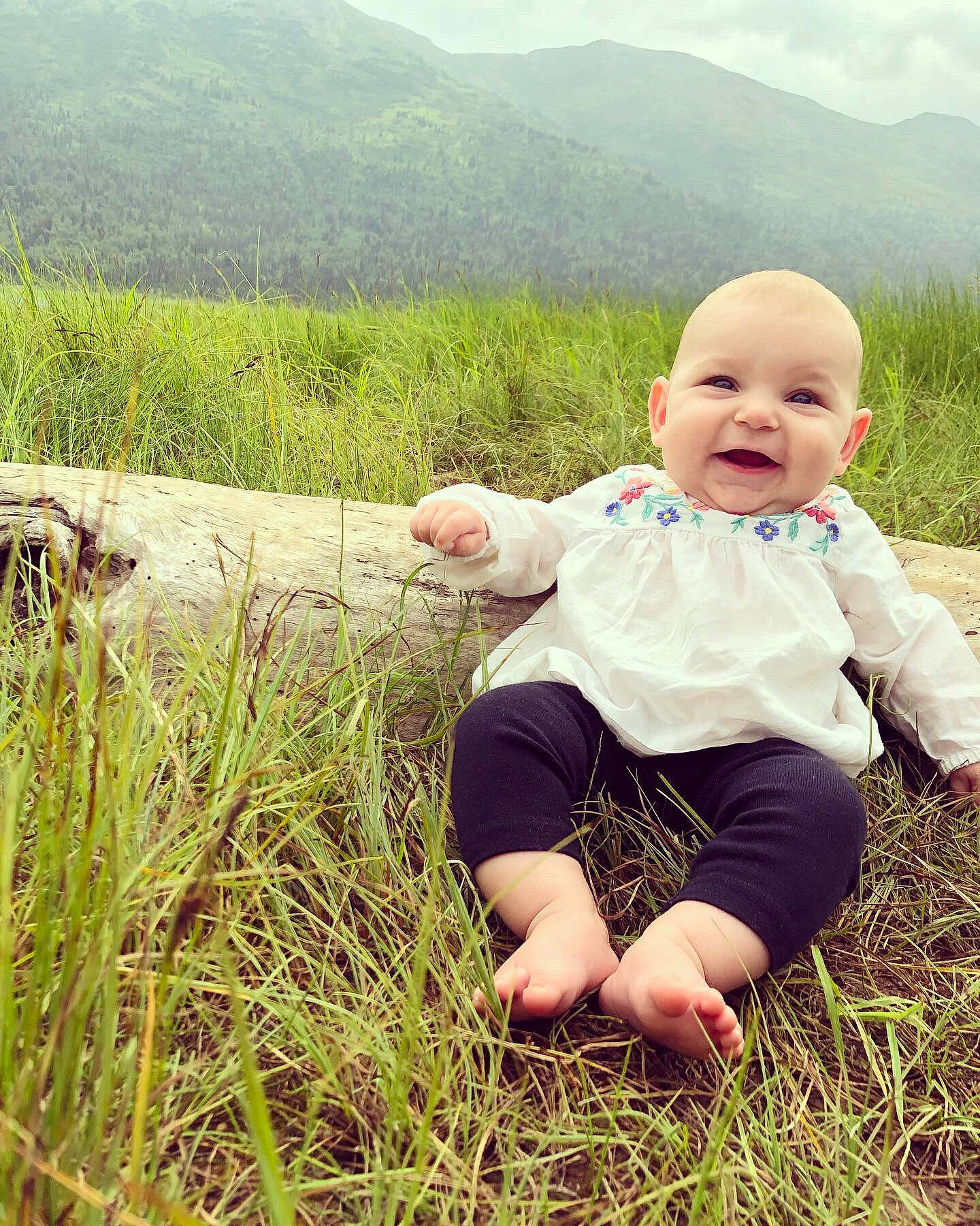 Aryanna joined the competition — help win amazing prizes! baby, child, face, grass, grass_family, grassland, green, happy, head, meadow, mountain, people, people_in_nature, person, photograph, skin, sky, smile, summer, toddler