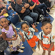 Nasir joined the competition — help win amazing prizes! children, kids, boys, girl, certificate, event, crowd, seated_adults, clothing, orange_shorts, bow_tie, peace_sign, floor, chairs, indoor, people, smiling, hair_bow, shoes, casual