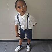 Jemmy participe au concours pour gagner de l'argent avec cette photo : boy, casual, casual_clothing, child, curious, floor, footwear, indoor, looking_up, navy_shorts, person, portrait, shorts, socks, standing, suspenders, tiles, wall, white_shirt, white_shoes