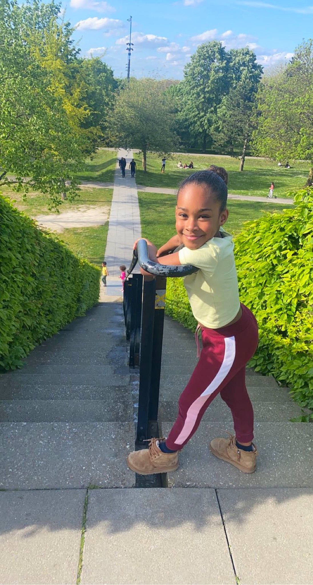 Inayah a rejoint le concours — aidez-le/la à gagner de superbes lots ! asphalt, child, footwear, fun, gesture, grass, green, happy, hedge, human_body, joy, leisure, people_in_nature, person, plant, public_space, recreation, sky, smile, street_light