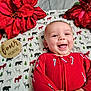 Remington is registered to the contest to win money with this photo: baby, smiling, infant, red_clothing, candy_cane_pattern, blanket, animal_print, poinsettia, flower, holiday_theme, face, happy, lying_down, cheerful, four_months_marker, indoors, cute, child, portrait, festive