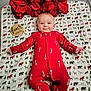 baby, infant, red_onesie, candy_cane_pattern, poinsettia, holiday_decor, blanket, animal_print, wooden_sign, four_months, smiling, lying_down, cute, festive, christmas_theme, child, indoors, portrait, happy, toddler