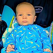 Remington is registered to the contest to win money with this photo: baby, infant, car_seat, blue_clothing, nike, blanket, child, face, portrait, serious, hand, young, sitting, indoors, person, cute, small, cozy, clothing_pattern, closeup