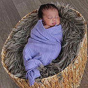 Aria is registered to the contest to win money with this photo: baby, newborn, sleeping, wrapped, blanket, basket, fur, floor, cozy, peaceful, infant, child, indoors, portrait, cute, soft, purple, woven, resting, head