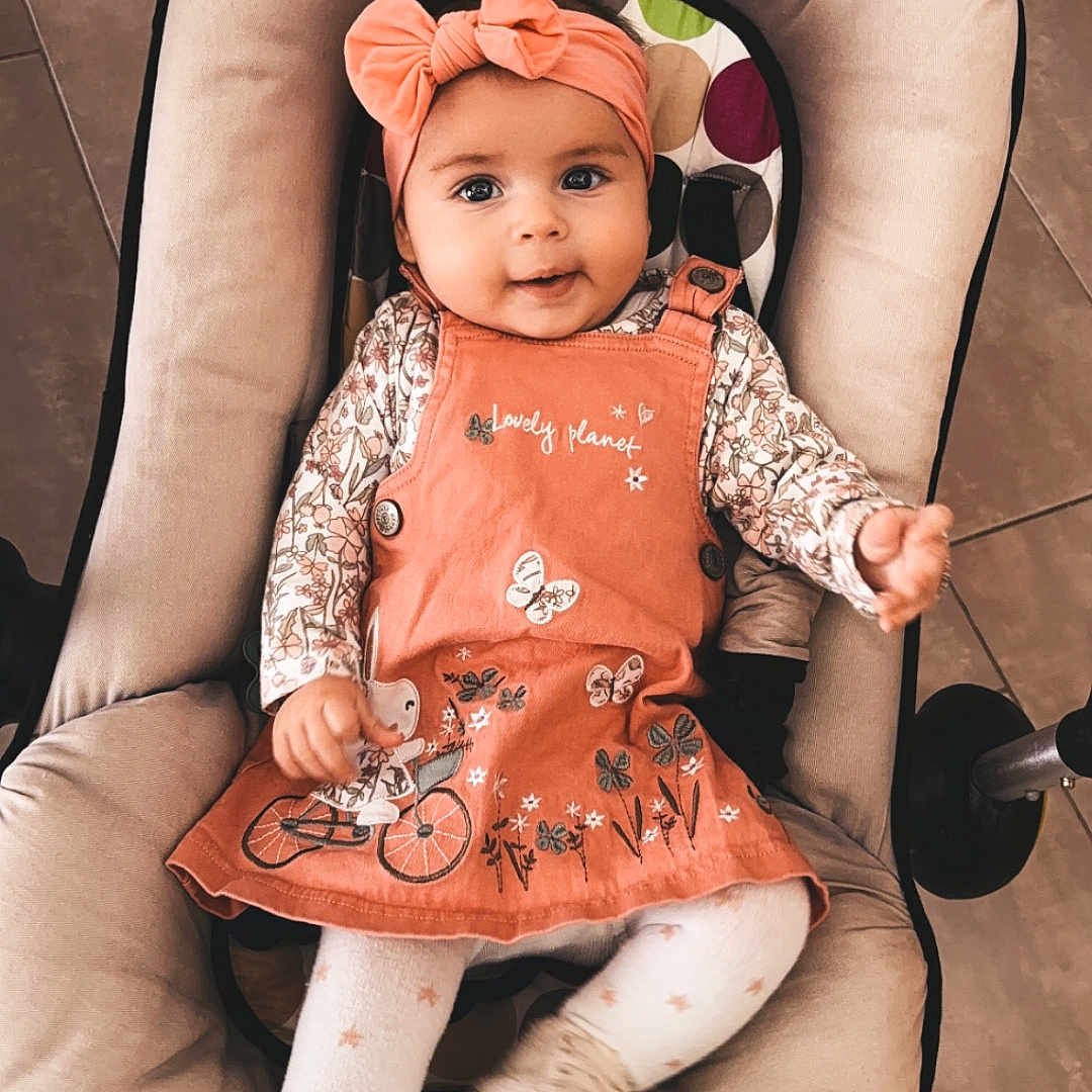 Jessye participe au concours pour gagner de l'argent avec cette photo : baby, car, clothing, face, footwear, furniture, happy, hat, head, infantbed, machine, person, photography, portrait, shoe, sitting, smile, transportation, vehicle, wheel