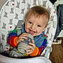Alfred joined the competition — help win amazing prizes! baby, bib, blue_eyes, bottle, cheerful, chewing, child, colorful_clothing, elephant_pattern, face, happy, high_chair, home, indoor, infant, person, seatbelt, smile, toy, wooden_floor