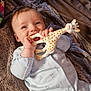 baby, infant, teething_toy, giraffe_toy, blanket, onesie, teddy_bear_print, chewing, lying_down, soft_texture, cozy, cute, happy, child, small_hands, indoor, portrait, smiling, light_blue_clothing, baby_toy