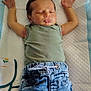 baby, sleeping, infant, jeans, green_shirt, arms_stretched, changing_pad, quilted, white_socks, soft_cloth, peaceful, indoors, child, cute, toddler, resting, casual_clothing, small_hands, relaxed, portrait