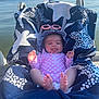 baby, infant, towel, pink_suit, hat, sunglasses, lake, water, outdoor, sunny, feet, tongue_out, smile, relaxing, summer, child, person, seat, blue, white