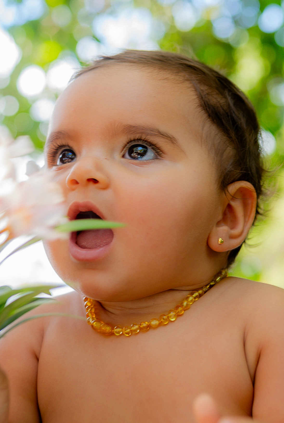 Kaya is registered to the contest to win money with this photo: baby, child, face, portrait, closeup, jewelry, earrings, necklace, flower, nature, greenery, bokeh, skin, cute, expression, open_mouth, eyes, outdoor, adorable, young
