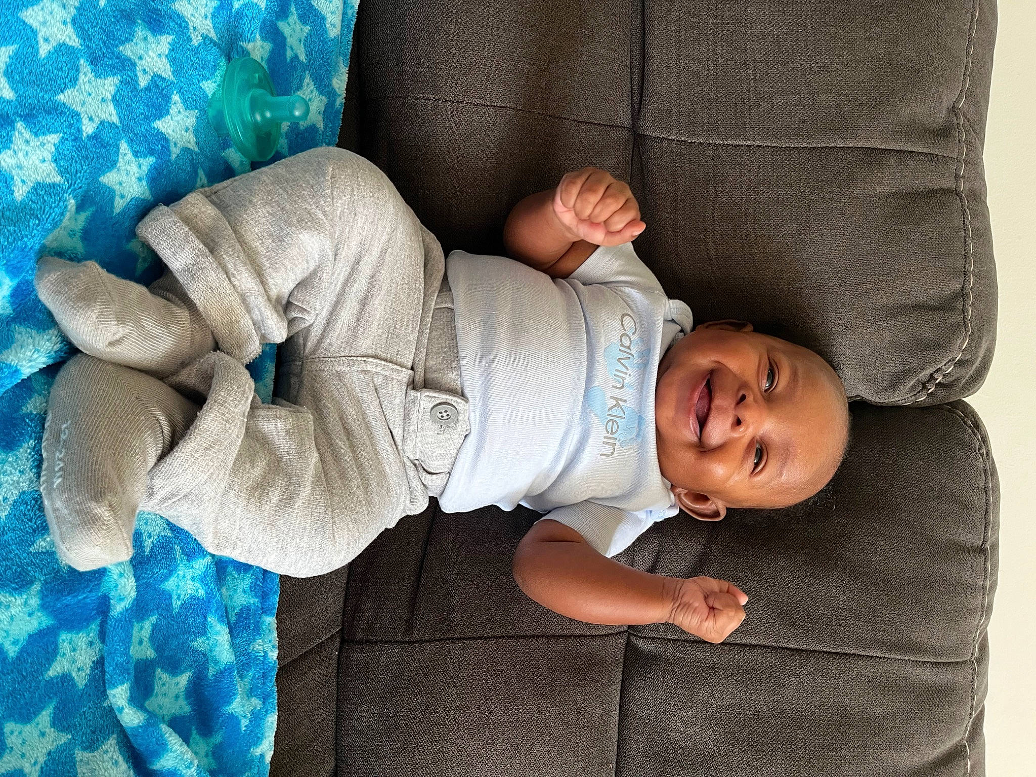 Michael is registered to the contest to win money with this photo: baby, baby_products, baby_safety, baby_sleeping, baby_toddler_clothing, child, comfort, elbow, hand, human_body, human_leg, joy, linens, pattern, person, room, sitting, skin, sleeve, smile