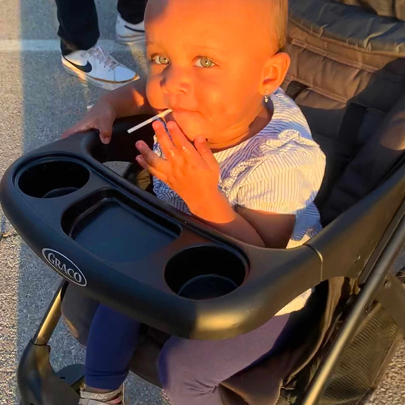 Kamryn is registered to the contest to win money with this photo: adult, baby, clothing, eating, face, food, footwear, glove, head, male, man, person, sandal, sitting, smoke, smoking