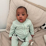 Elaÿdjah a rejoint le concours — aidez-le/la à gagner de superbes lots ! baby, infant, onesie, pacifier, pillow, bed, plush_toy, panda, child, person, indoor, curious_expression, clothing, sleepwear, cute, sitting, soft_fabric, home, comfort, young_child