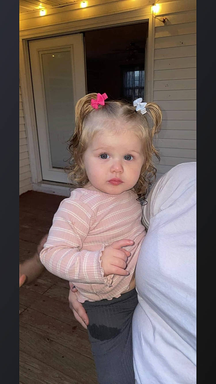 Rosabella is registered to the contest to win money with this photo: baby, baby_toddler_clothing, chair, cheek, child, door, dress, event, fashion_accessory, fur, gesture, hair_accessory, happy, headband, headpiece, jewellery, lip, person, pink, sleeve