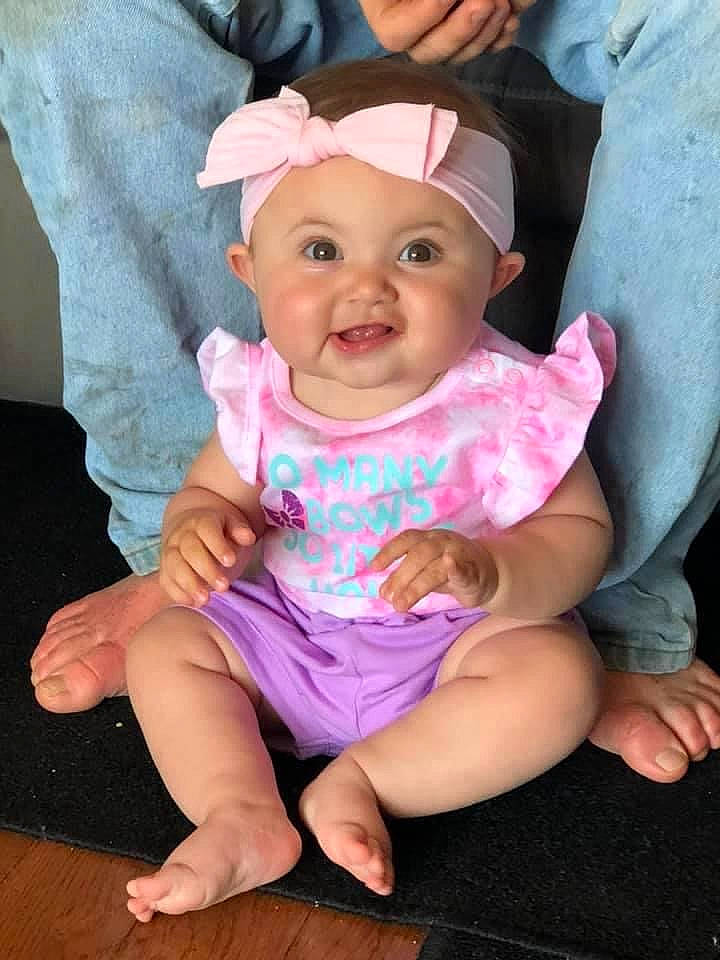 London is registered to the contest to win money with this photo: baby, baby_toddler_clothing, barefoot, cap, cheek, child, comfort, finger, foot, fun, happy, headgear, headwear, joy, magenta, mouth, person, pink, purple, skin