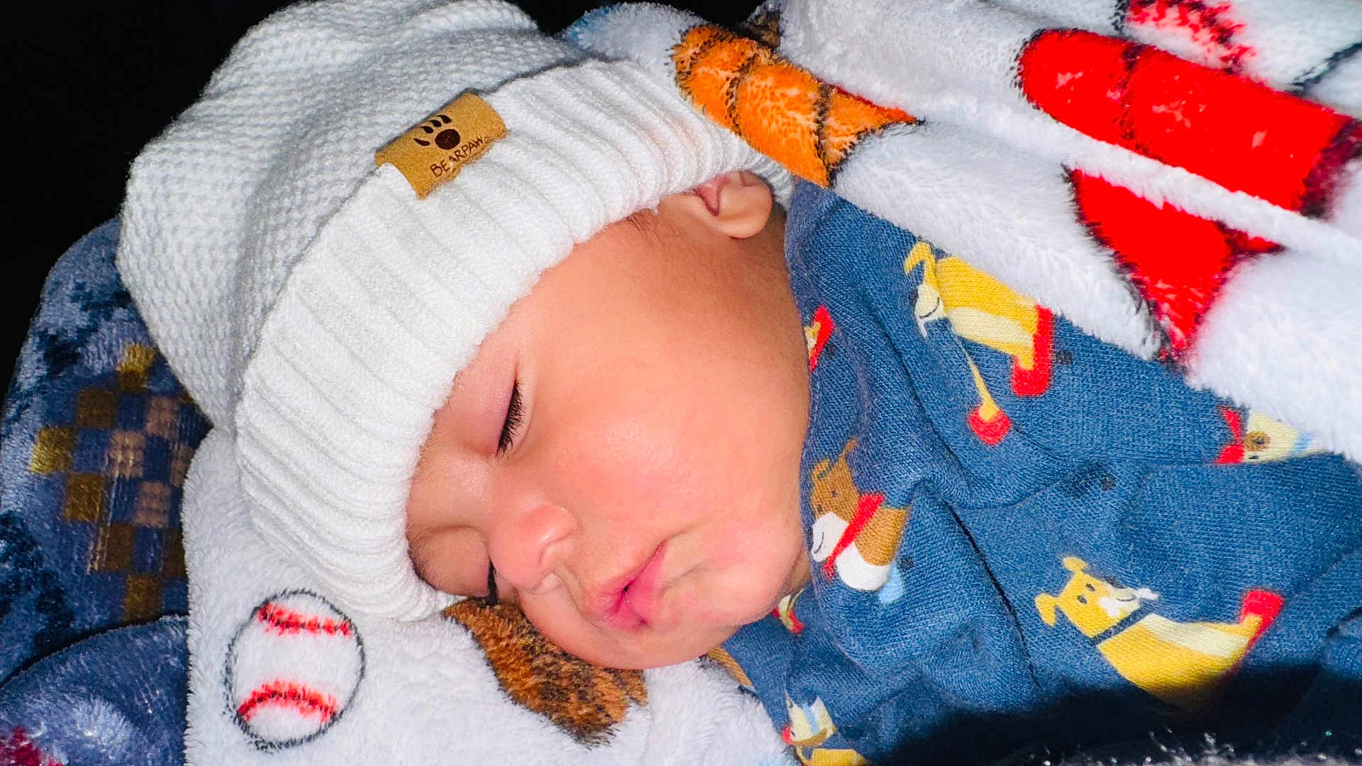 Yasser Izam is registered to the contest to win money with this photo: baby, sleeping, hat, blanket, cozy, child, face, cute, knit_hat, infant, soft, warm, dog_pattern, clothing, portrait, peaceful, closeup, rest, comfort, indoors