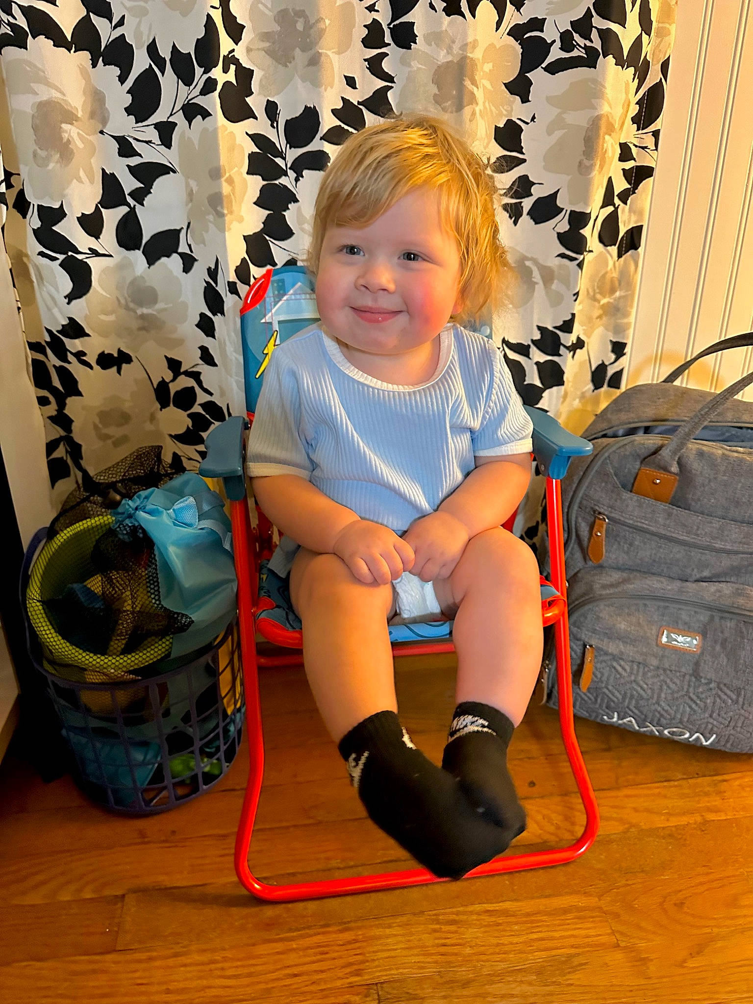Jaxon is registered to the contest to win money with this photo: baby, baby_toddler_clothing, bag, basket, child, electric_blue, fashion_accessory, flooring, foot, fun, happy, human_leg, joy, knee, luggage_and_bags, pattern, person, room, sitting, smile