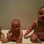 Eden is registered to the contest to win money with this photo: baby, doll, toy, child, naked, sitting, three, skin, face, arm, leg, expression, indoor, table, background, cute, chubby, real, plastic, comparison