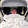 animal_print, baby, blanket, canopy, car_seat, cheeks, fabric_pattern, headrest, hood, indoors, infant, newborn, portrait, seat, smile, smiling_face, soft_texture, stroller, swaddle, warning_label