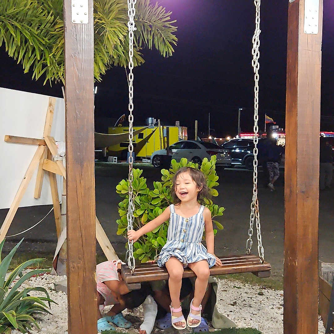 Camila is registered to the contest to win money with this photo: child, clothing, face, female, footwear, girl, grass, head, jar, outdoorplayarea, outdoors, person, photography, plant, planter, playarea, portrait, pottedplant, sandal, wood