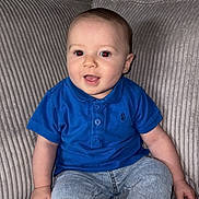 Mayronn participe au concours pour gagner de l'argent avec cette photo : baby, child, smiling, sitting, couch, blue_shirt, striped_socks, jeans, indoor, happy, face, portrait, young_child, cute, infant, casual_clothing, comfortable, home, person, young
