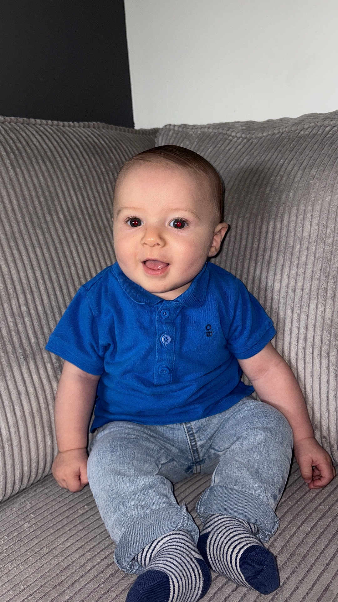 Mayronn participe au concours pour gagner de l'argent avec cette photo : baby, child, smiling, sitting, couch, blue_shirt, striped_socks, jeans, indoor, happy, face, portrait, young_child, cute, infant, casual_clothing, comfortable, home, person, young