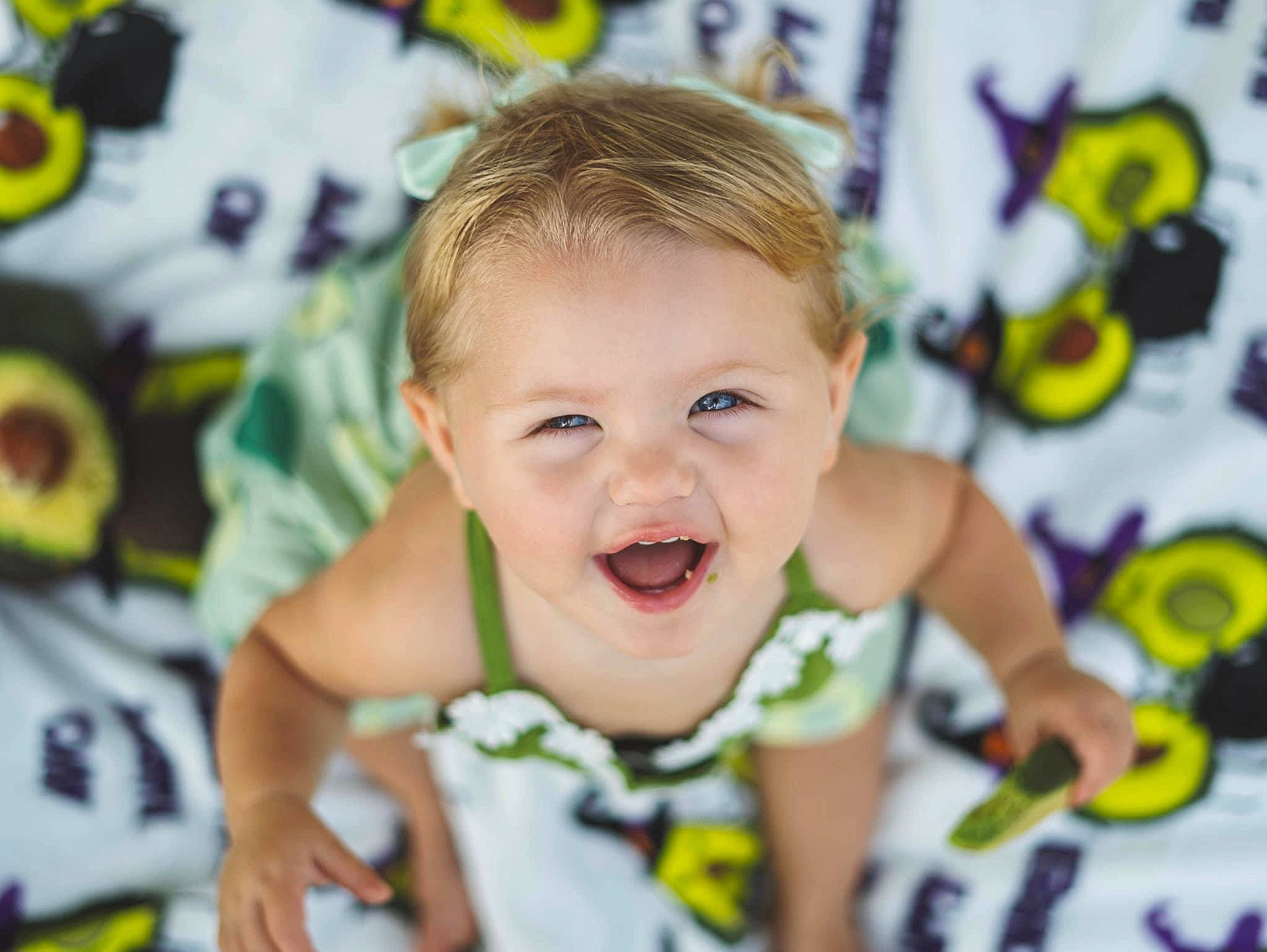 Penelope is registered to the contest to win money with this photo: arm, baby, baby_products, baby_toddler_clothing, child, eyelash, facial_expression, finger, fun, happy, leisure, nose, person, play, room, sleeve, smile, t_shirt, toddler, white