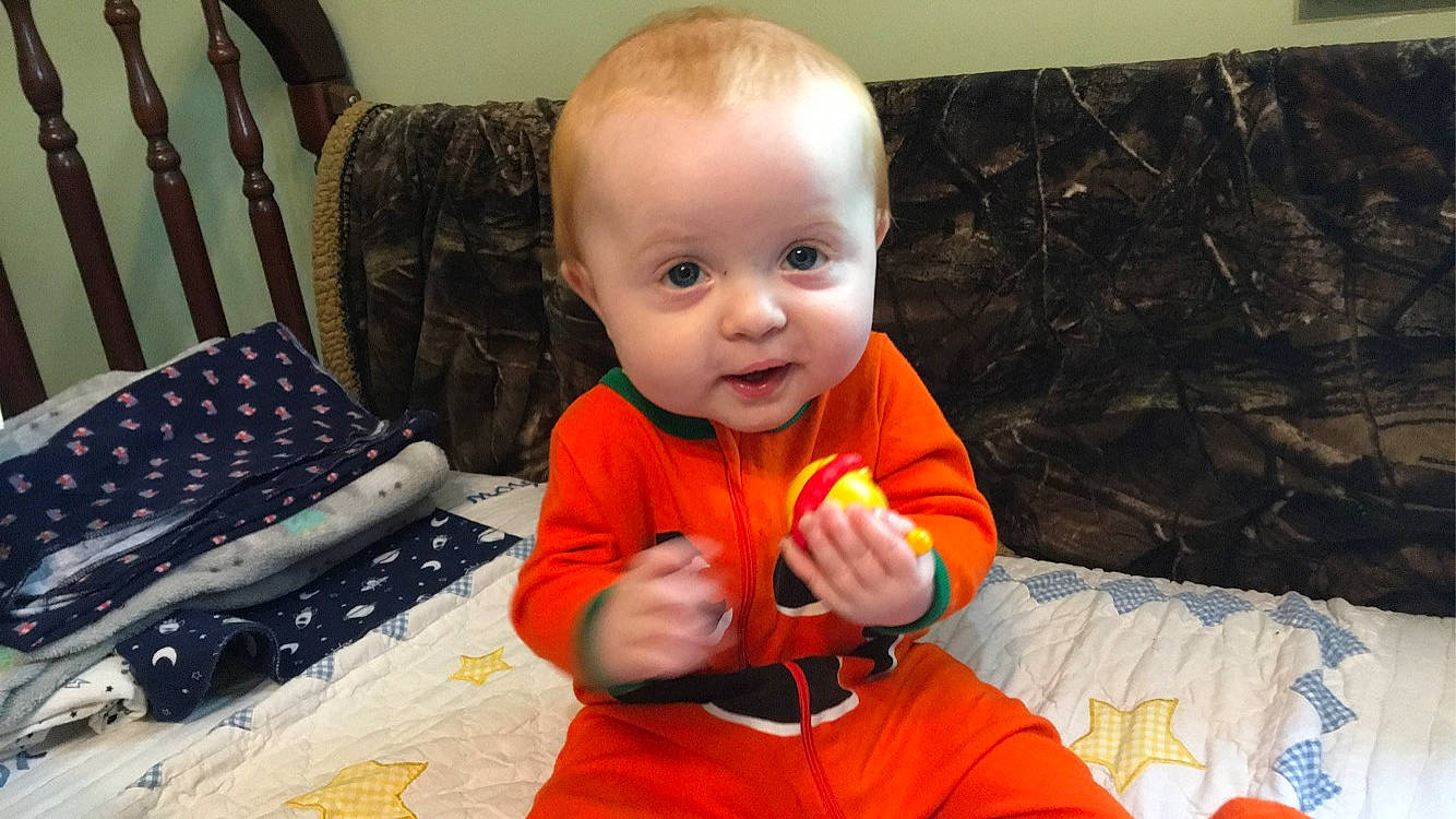 Carson is registered to the contest to win money with this photo: baby, cheek, child, finger, mouth, nose, orange, person, toddler