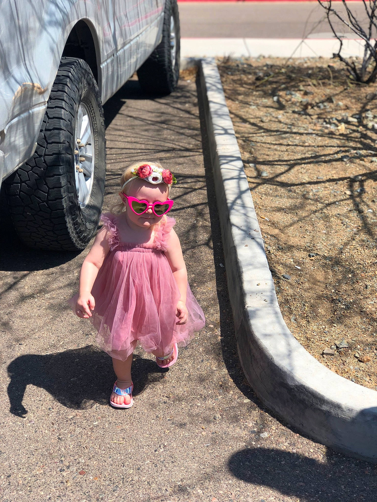 Bexlee is registered to the contest to win money with this photo: alloy_wheel, asphalt, automotive_lighting, automotive_tire, car, dress, fender, goggles, grass, hat, person, plant, road, road_surface, sun_hat, sunglasses, tints_and_shades, tire, tread, vehicle