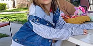 Kara is registered to the contest to win money with this photo: building, casual_clothing, chair, child, cushion, daylight, denim_jacket, girl, grass, happy, hoodie, outdoor, picnic_table, playful, plush, sidewalk, smiling, toy, unicorn, window