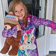 Kara joined the competition — help win amazing prizes! child, girl, teddy_bear, stuffed_animal, unicorn, dress, colorful_clothing, smile, happy, indoors, door, window, long_hair, toy, winter_hat, playful, portrait, person, cute, holding