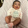 baby, blanket, child, cozy, cute, face, footwear, hand, happy, indoors, infant, onesie, pink, portrait, seated, skin, smiling, socks, soft, textile