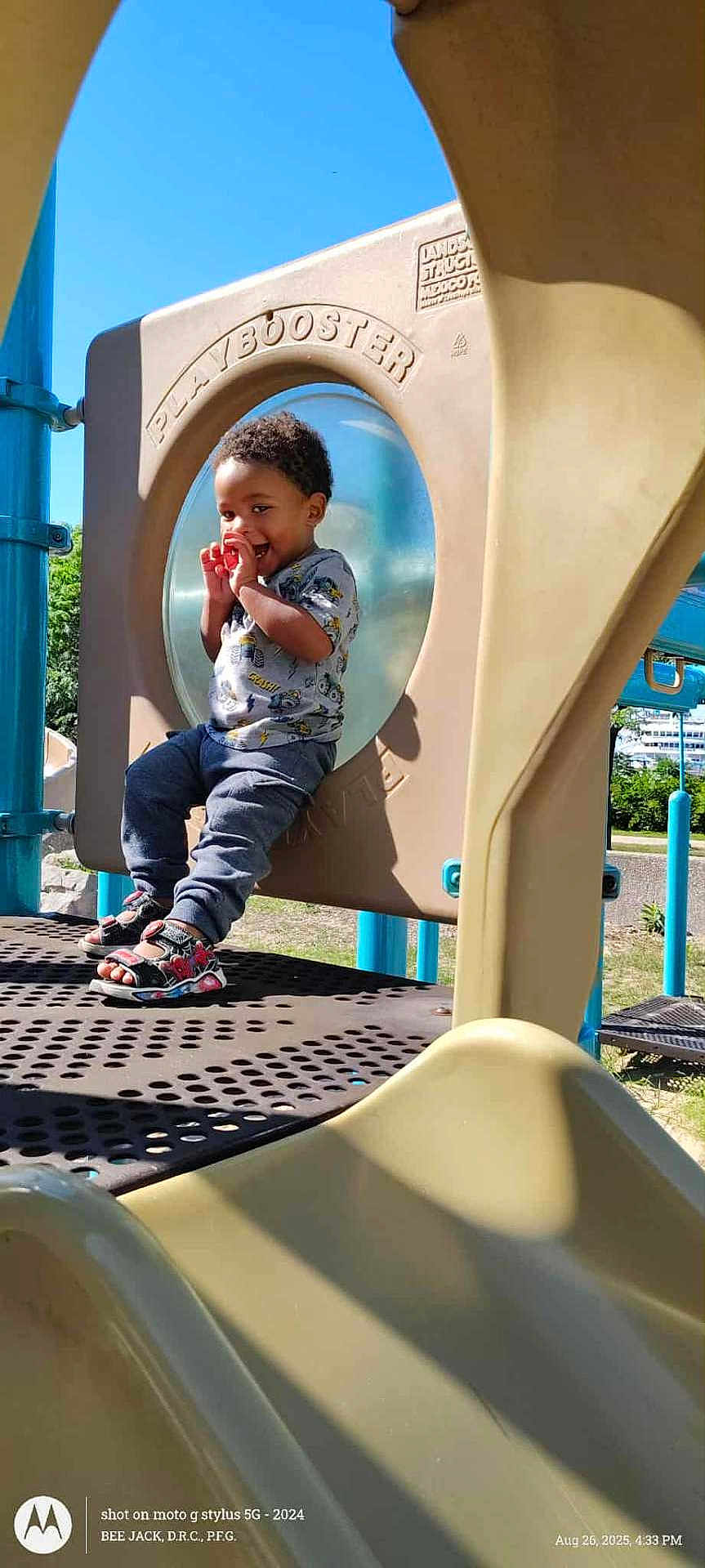 Zavion joined the competition — help win amazing prizes! toddler, child, playground, play_structure, slide, outdoor, smiling, happy, sunny, daytime, blue_sky, clothing, sandals, grass, trees, metal, plastic, fun, park, person